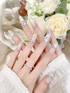 Detail of almond cat eye fake nails with 3D crystal rhinestones and silver cat eye gradient