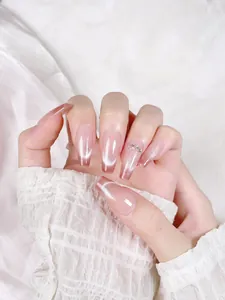 Detail of nude gradient cat-eye press-on nails with glitter silver luster and rhinestones