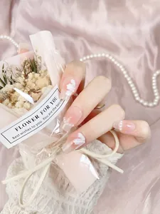Detail of handmade press-on nails featuring 3D white flowers, pearls and silver glitter