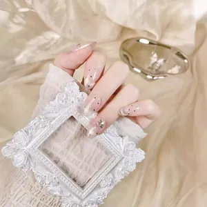 Handmade press-on nails with nude pink base, silver cat-eye effect, and butterfly gems
