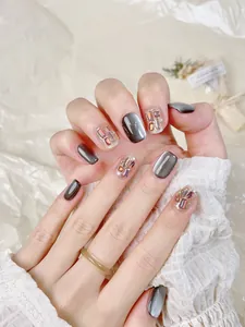 Vue détaillée d'ongles gris œil-de-chat avec strass colorés et paillettes brillantes