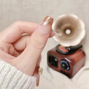 Brown gradient press-on nails with sparkling rhinestones and silver glitter accents
