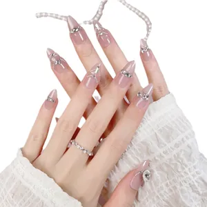 Handmade almond press-on nails in nude cat-eye glitter with silver rhinestone accents