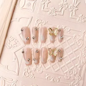 Handmade nude pink cat eye press-on nails with 3D gold butterflies and small rhinestones