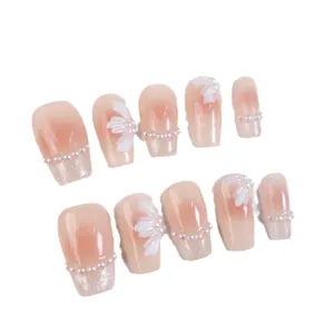 Pink gradient press-on nails with 3D white flower petals and pearl accents