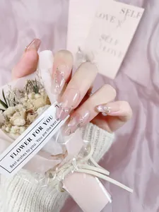 Macro detail of pink gradient press-on nails with pearl accents and gold line design