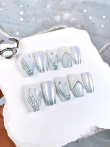 Détail de faux ongles faits main avec relief sirène, perles et dégradé bleu élégant