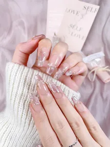 Macro detail of nude pink cat-eye press-on nails with pearls and glitter on coffin shape
