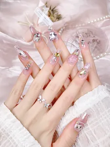Detail of luxury long coffin press-on nails with 3D crystal hearts and butterfly ring