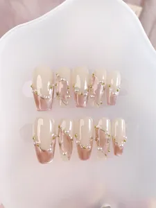 Detailed shot of coffin press-on nails with cat-eye effect, pearls and gold wire accents