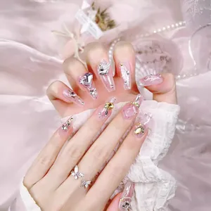Handmade press-on nails set with pink glitter, 3D butterfly, and crystal heart rhinestones