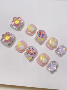 Detail von 3D-Harz-Charms auf rosa und glitzernden silbernen Zehennägeln für Kinder
