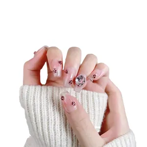 Handmade short press-on nails with pink glitter, gradient blush, and rhinestone accents