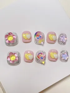 Detail von handgefertigten Kindernägeln mit 3D-Lutscher- und Blumen-Dekorationen
