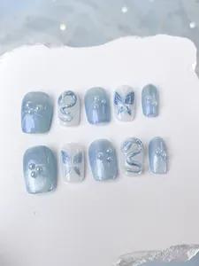 Detail of blue cat-eye press-on nails with white butterfly art and 3D snake design