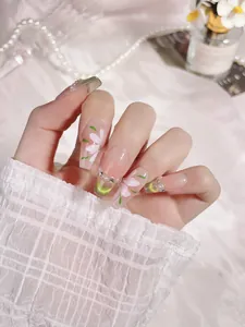 Detailed close-up of handmade green coffin press-on nails with hand-painted floral motifs