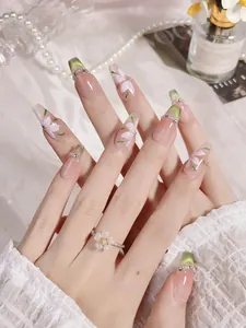 Detailed view of handmade green floral press-on nails with cat-eye and crystal accents