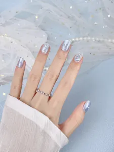 Detail of light blue cat-eye nails with silver 3D butterfly and snake art accents