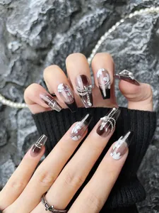 Close-up of handmade coffin fake nails with black gradient, bows, and pearl accents