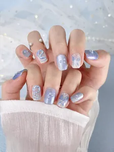 Detail of handmade butterfly press-on nails with 3D pearls and blue cat-eye effect