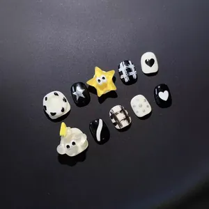 Uñas postizas hechas a mano para niños con patrones en blanco y negro y dijes 3D