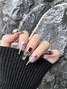 Detail of long coffin press-on nails with 3D pearls and metallic chain charms