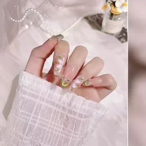 Handmade green cat eye press-on nails with white flower art and rhinestone details
