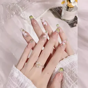 Hand-painted green forest nails with floral patterns, cat-eye effect, and pearl accents