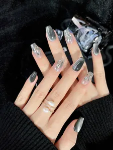 Détail de faux ongles œil-de-chat gris avec art métallique 3D argenté et paillettes