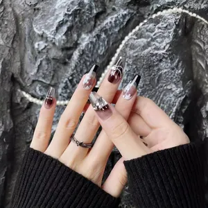 Handmade French press-on nails with black gradient, rhinestones, and pearls on model