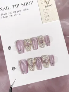 Detail of purple cat-eye press-on nails with 3D silver waves and pearl accents