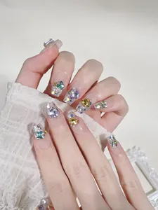Detailed view of handmade press-on nails with luxury colorful rhinestones and 3D gems