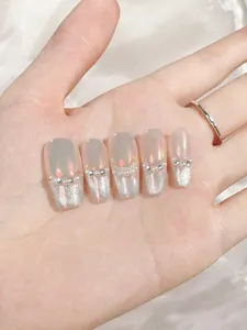Detail of handmade press-on nails with silver cat-eye glitter and delicate white pearls