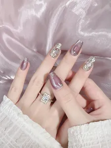 Detail of purple cat eye and champagne gold metallic press-on nails with rhinestones