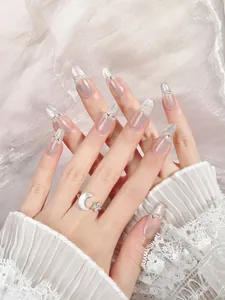 Detail of long almond nails with aurora pink finish, silver glitter and pearls