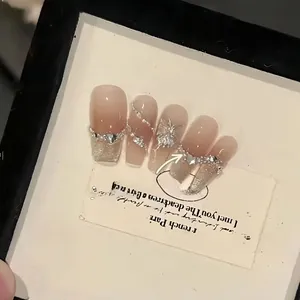 Handmade nude gradient press-on nails with silver glitter and 3D butterfly charms