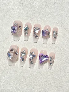 Detailed macro view of long trapezoidal press-on nails with purple 3D butterfly rhinestones