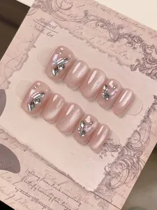 Close-up of 10-piece handmade pink cat-eye press-on nails with silver butterfly and rhinestones