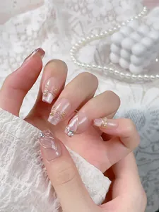 Close-up of pink cat-eye press-on nails with mermaid tail lines and pearl accents
