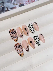 Detail of handmade leopard print press-on nails with hand-painted cheetah art in a gift box