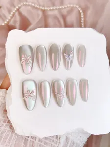 Détail de faux ongles œil-de-chat argentés avec papillons 3D et finition aurore