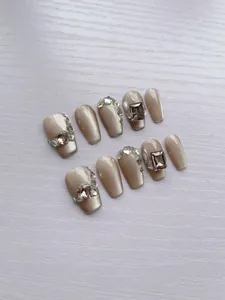 Détails de faux ongles faits main avec paillettes champagne et strass de luxe brillants
