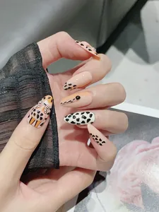 Macro view of handmade stiletto press-on nails featuring hand-painted leopard and cow patterns
