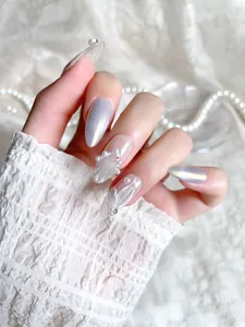 Detail of silver cat-eye press-on nails with handmade pearls and white painted lines