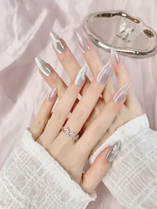 Détail de faux ongles faits main en amande avec fini perlé et papillons en relief