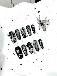 Macro detail of Y2K coffin press-on nails featuring 3D silver butterflies and chains
