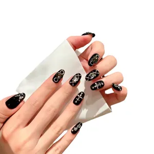Glossy black handmade press-on nails with silver gothic crosses and sparkling rhinestones