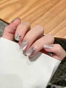 Detailed view of handmade silver cat eye nails with shimmering glitter and silver beads