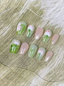 Dettaglio di unghie finte fatte a mano con fiori di loto, perle e decorazioni d'arte