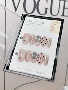 Detail of handmade nude pink cat-eye press-on nails with silver crystals and 3D metal art